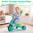 Toddler tricycle in green with a sturdy metal frame, triangular construction, and detachable rear storage basket for toys.