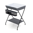 Folding baby change table in grey with storage basket and shelf, designed for convenient diaper changes and.