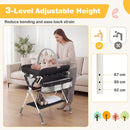 Baby changing table in black with adjustable height, storage bag, and shelf for easy access to baby essentials.