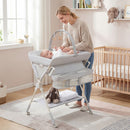 Baby changing table in grey with storage bag and shelf, adjustable height, and secure design for newborns and infants.