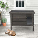 Weatherproof wooden feral cat house with a cozy escape door, designed for multiple cats, perfect for outdoor.