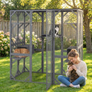 Large outdoor cat house in grey with weatherproof asphalt roof, featuring multiple platforms and condos for play and rest.