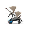 Almond Beige e-Gazelle S with upper seat parent-facing and lower seat forward-facing. One seat is included; the additional seat shown is sold separately.