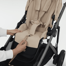 Close-up of the Almond Beige e-Gazelle S seat as the one-pull harness is tightened.