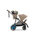 Almond Beige e-Gazelle S with one seat and the included shopper basket carrying flowers. Flowers shown for illustration.