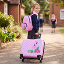 Kid pulling a pink flamingo luggage set with spinner wheels, including an 18" suitcase and 12" backpack for travel.