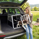 Travel dog crate in a car trunk, featuring a chew-proof aluminum frame and lockable door for secure pet transport.