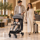 Rever Bebe Joy stroller in dark grey — hotel arrival lifestyle scene