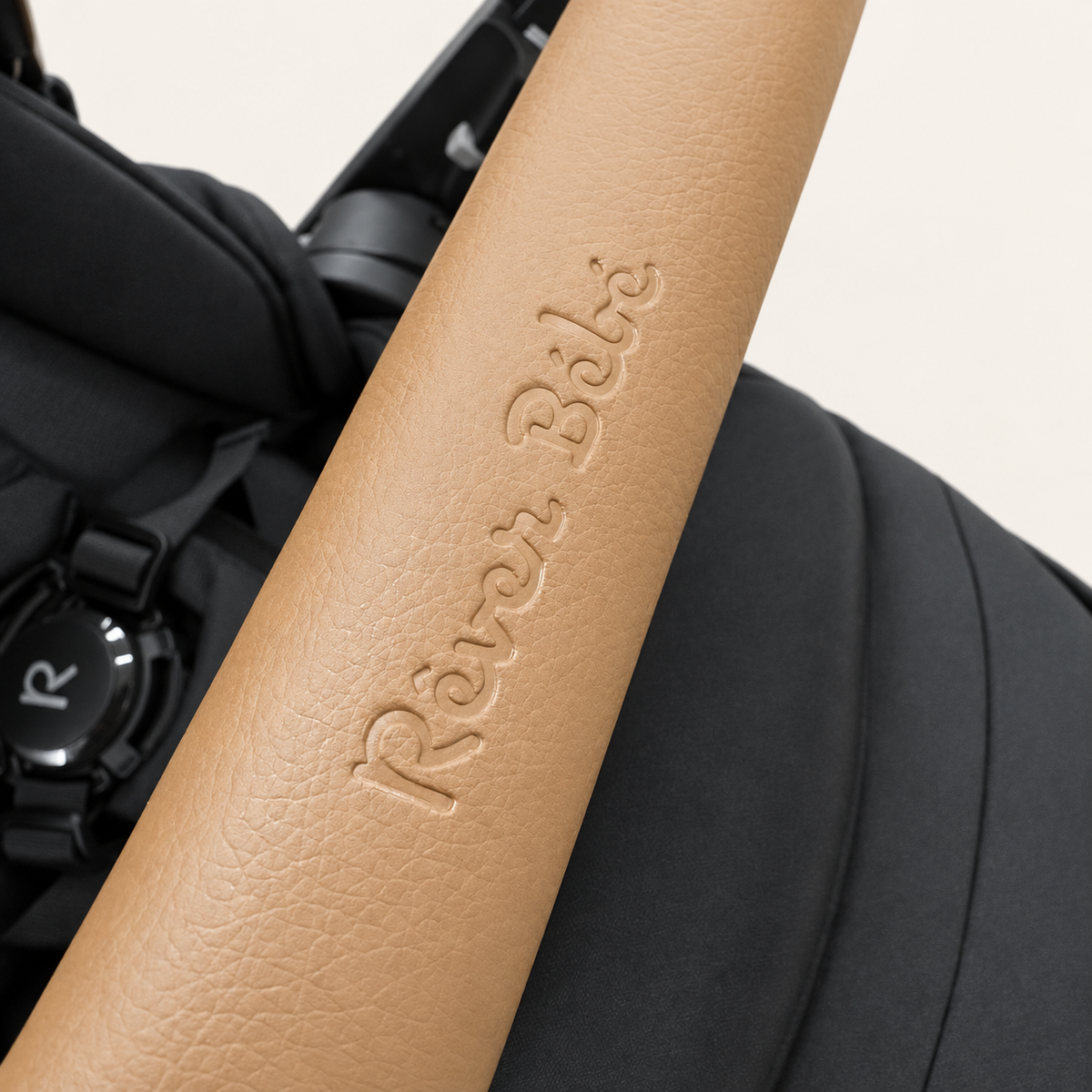 Close-up of VEVO tan leather-look bumper bar embossed with Réver Bébé