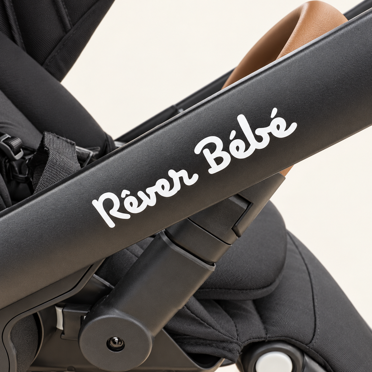 Close-up of the Réver Bébé logo and seat connection on the VEVO frame